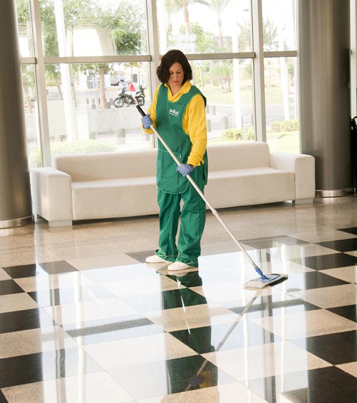 Una operaria de Brócoli limpiando el suelo de un recibidor de una empresa
